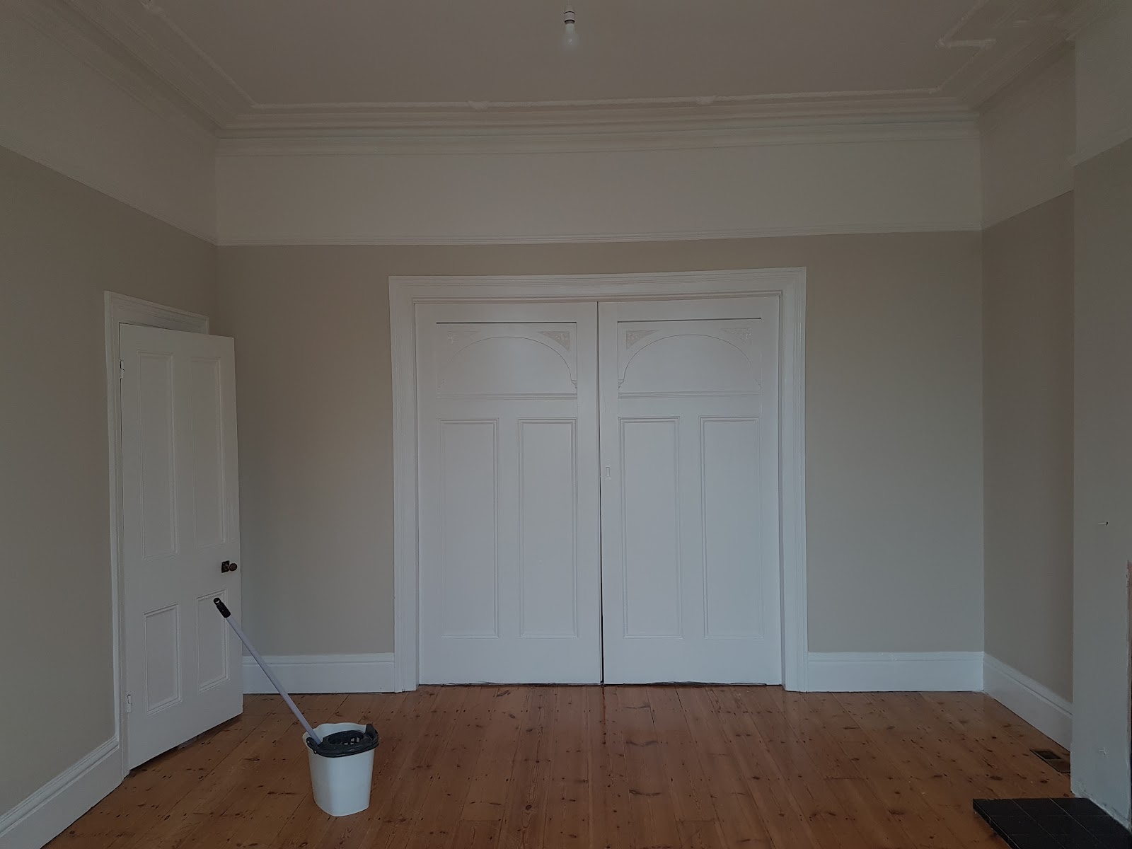 A Plymouth period room repainted in warm stone with crisp white double doors and woodwork